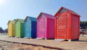 Brightly painted beach huts on beach